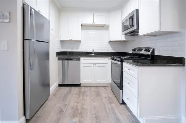a kitchen with stainless steel appliances granite countertop a refrigerator and a stove
