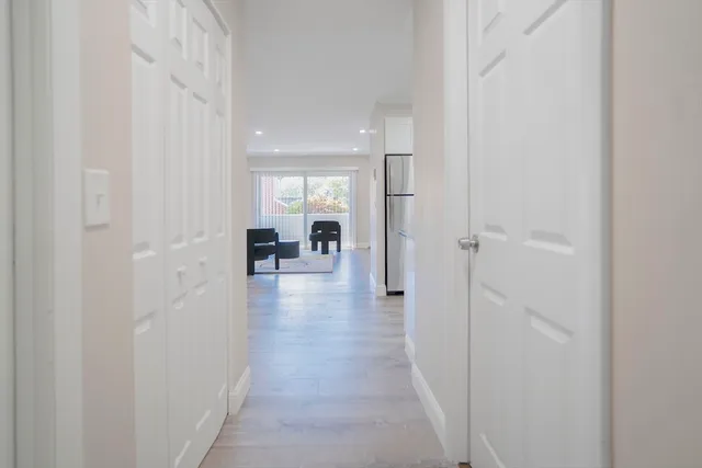 a view of a hallway with a livingroom and a chair