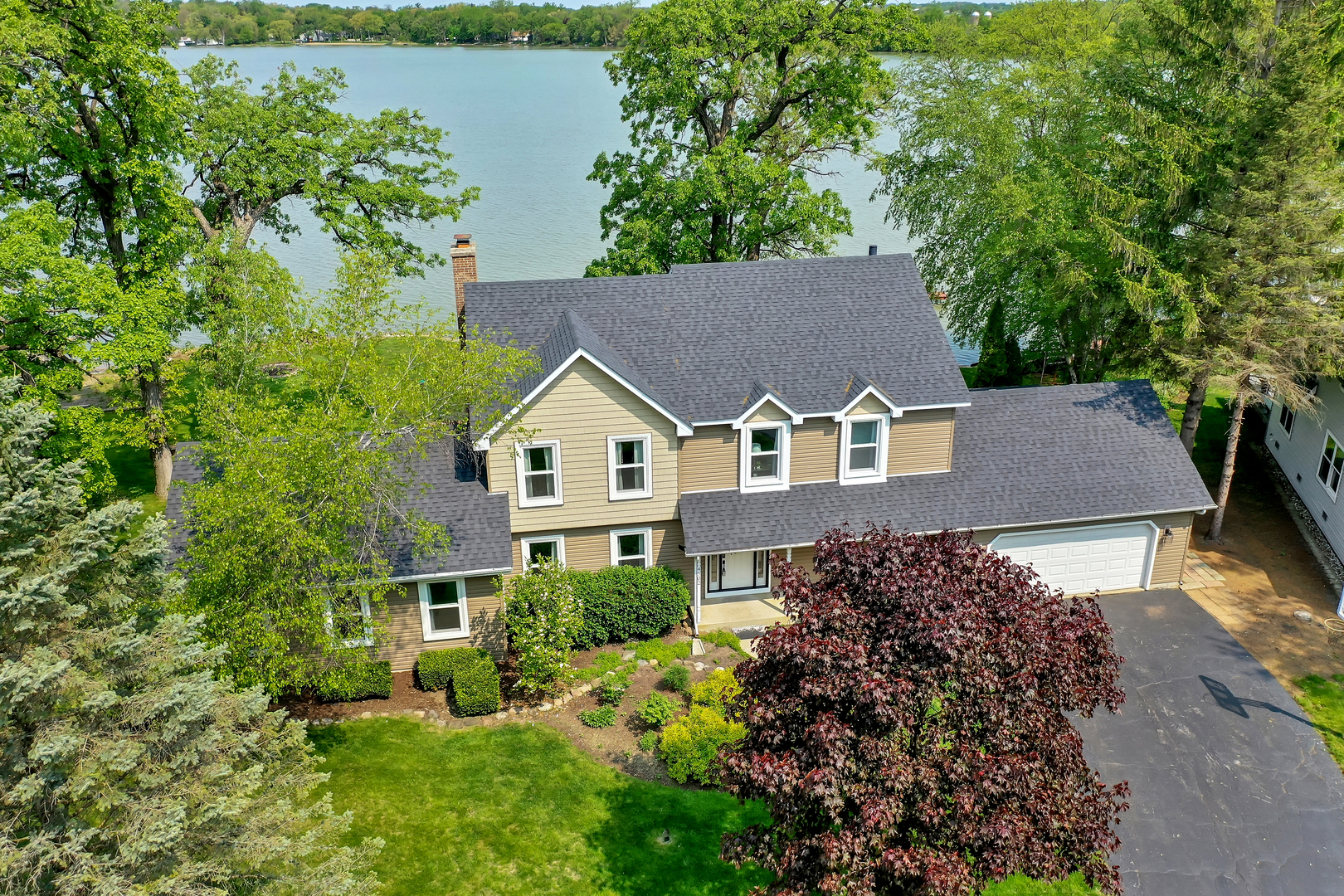 an aerial view of house with yard and trees in the background