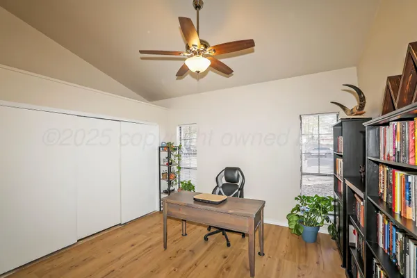 a view of a workspace with furniture and a book shelf