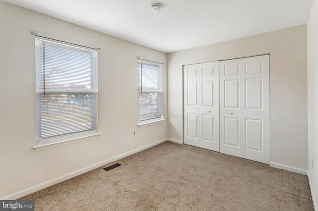 an empty room with windows and closet