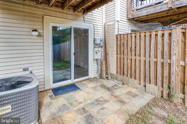 a view of a backyard with a chair and table in the patio