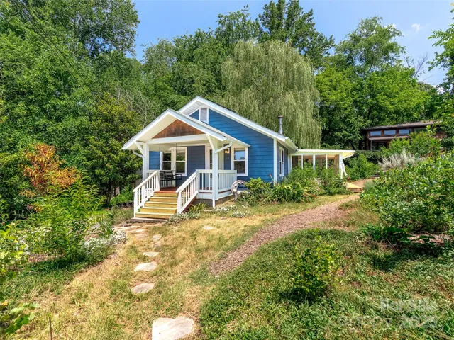 a view of a house with a yard and sitting area