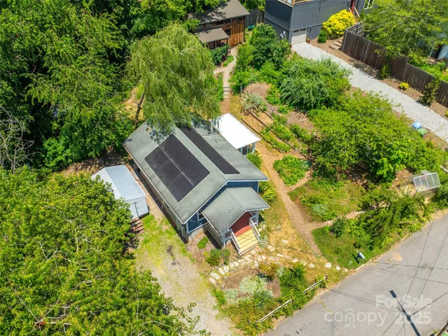 an aerial view of a house with garden space and street view