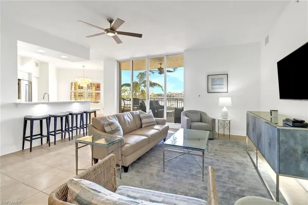 a living room with furniture a flat screen tv and a large window
