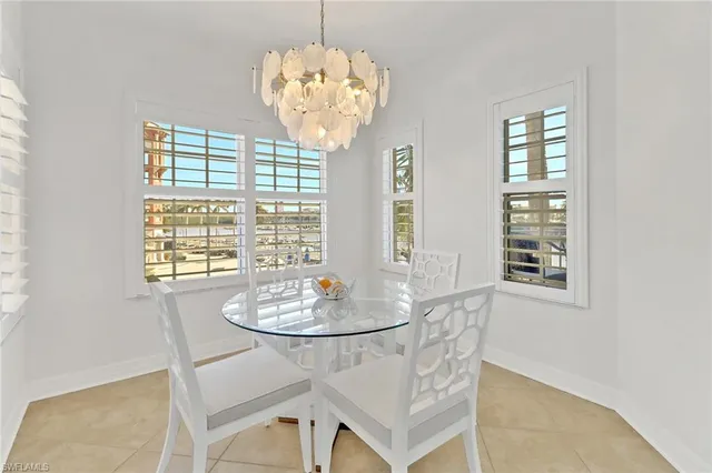 a dining room with wooden floor and chandelier
