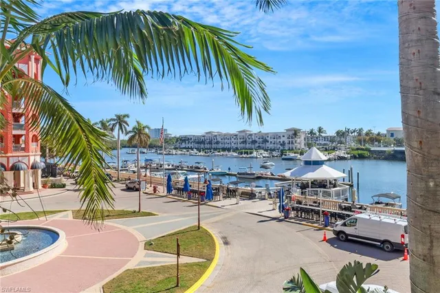 a view of a swimming pool with a lounge chair and palm trees