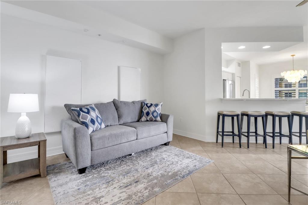 450 Bayfront Place, Unit 4206 Naples, FL 34102 - Photo 5 of 27 a living room with furniture a lamp and a potted plant