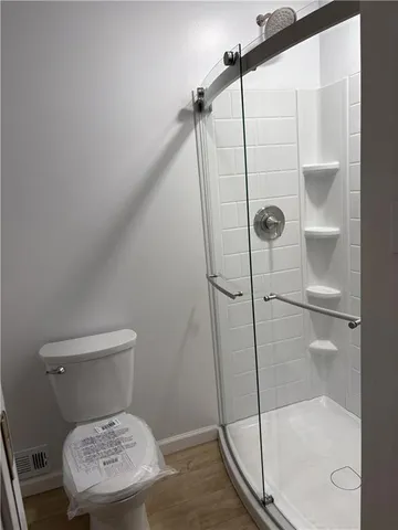 a bathroom with a toilet and a shower
