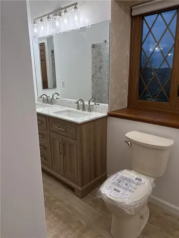 a bathroom with a sink a toilet and mirror