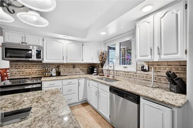 a kitchen with stainless steel appliances granite countertop a sink stove and cabinets