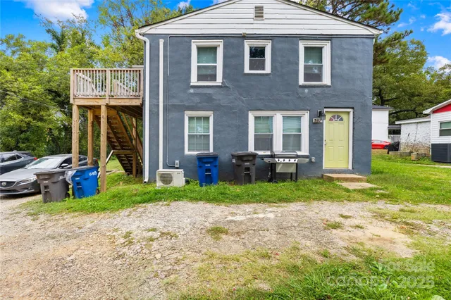 a view of a house with a yard and lawn chairs with a fire pit