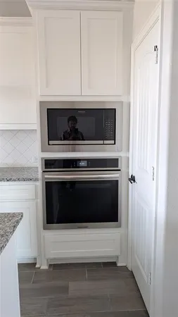 a kitchen with a stove and white cabinets