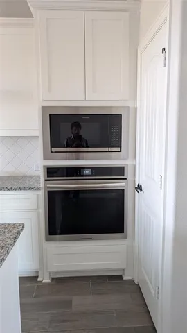 a kitchen with a stove and white cabinets