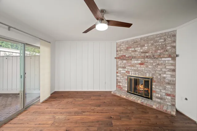 wooden floor fireplace and windows in an empty room