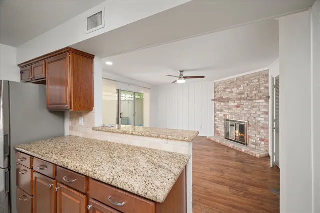 a kitchen with granite countertop a sink stove and refrigerator