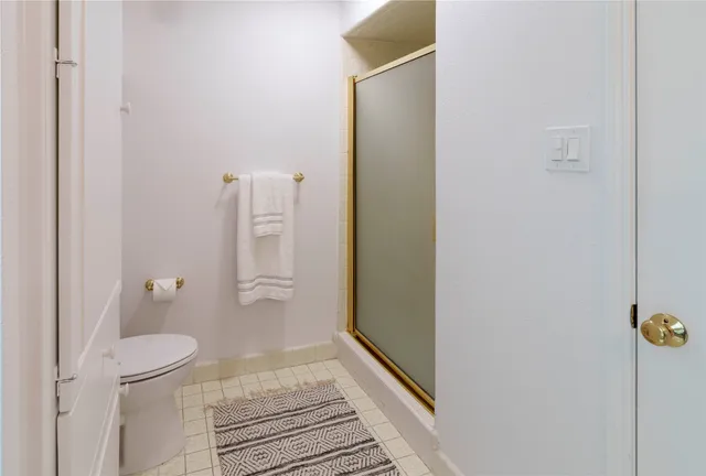 a bathroom with a granite countertop shower and a toilet