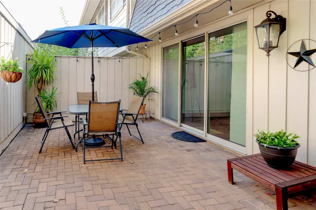 a view of patio with a table and chairs under an umbrella