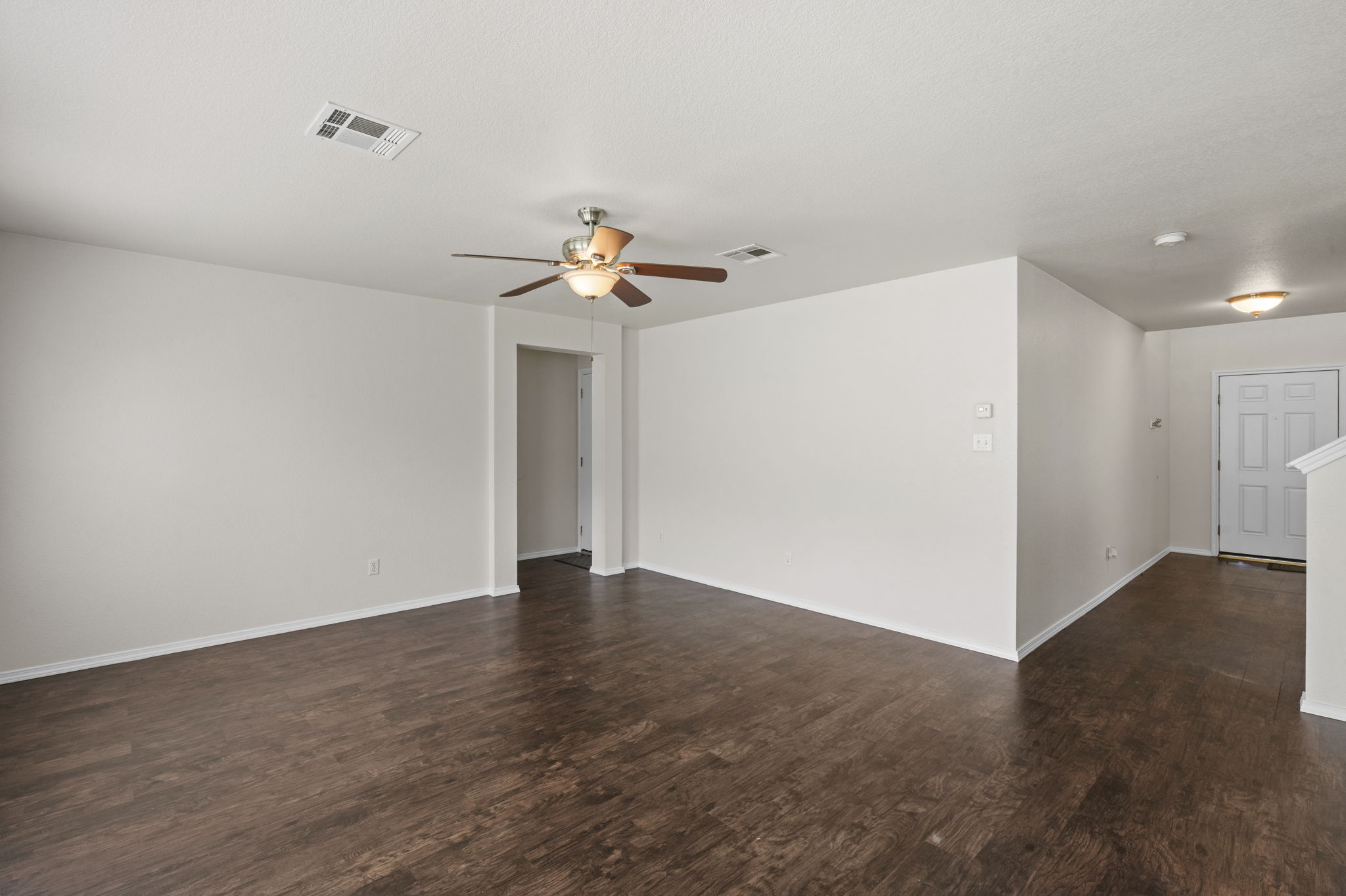 208 Dandelion Loop Kyle, TX 78640 - Photo 18 of 39 The property features LVT wood-style flooring, light-colored walls, and a ceiling fan with integrated lighting