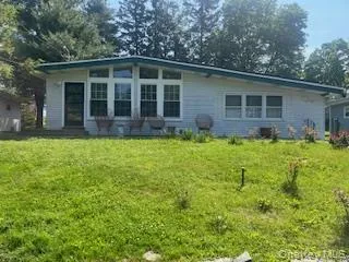 a view of a house with a yard and sitting area