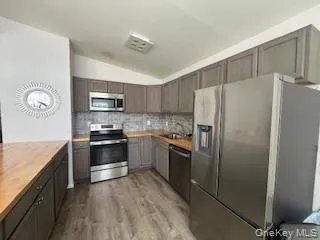a kitchen with stainless steel appliances granite countertop a refrigerator stove and sink