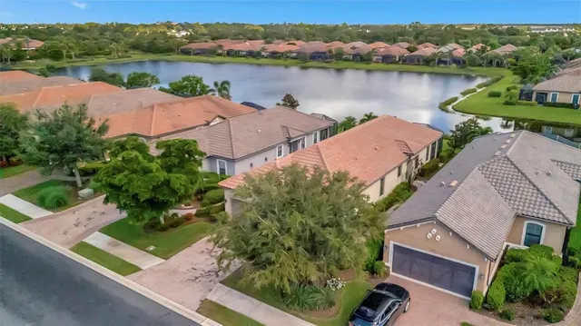 an aerial view of a house with outdoor space and lake view