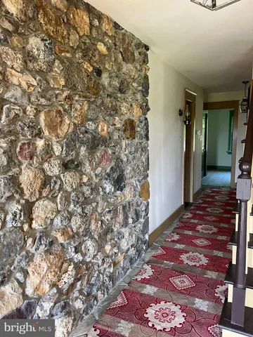 a view of a hallway with wooden floor and a chandelier