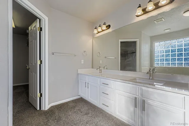 a bathroom with double sink and a mirror