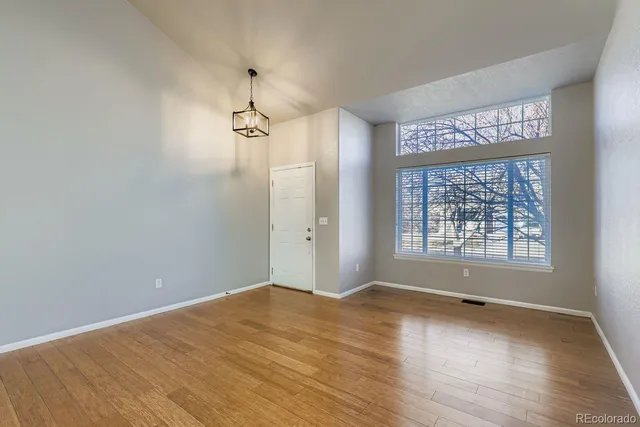 a view of a big room with windows and chandelier fan