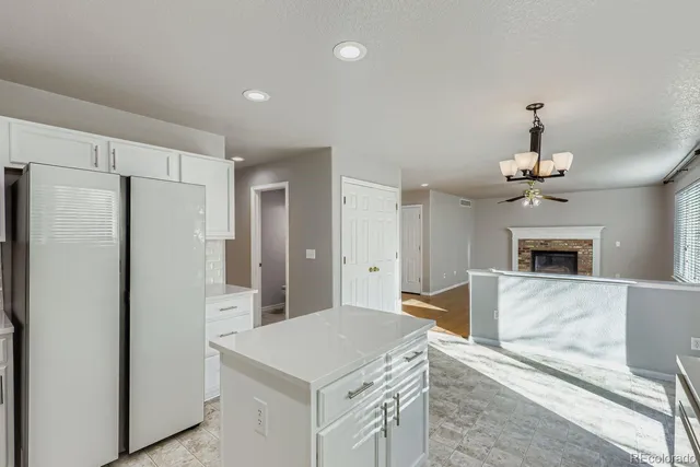 a kitchen that has a refrigerator a stove top oven a counter space and a chandelier