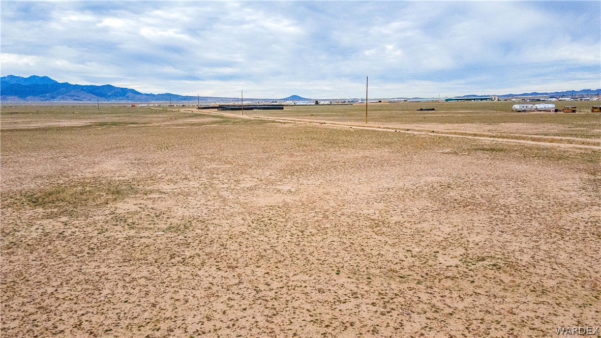 0 East Parker Road, Unit 119 Kingman, AZ 86401 - Photo 14 of 16 Expansive open land with a dirt road, distant mountains, and scattered brush