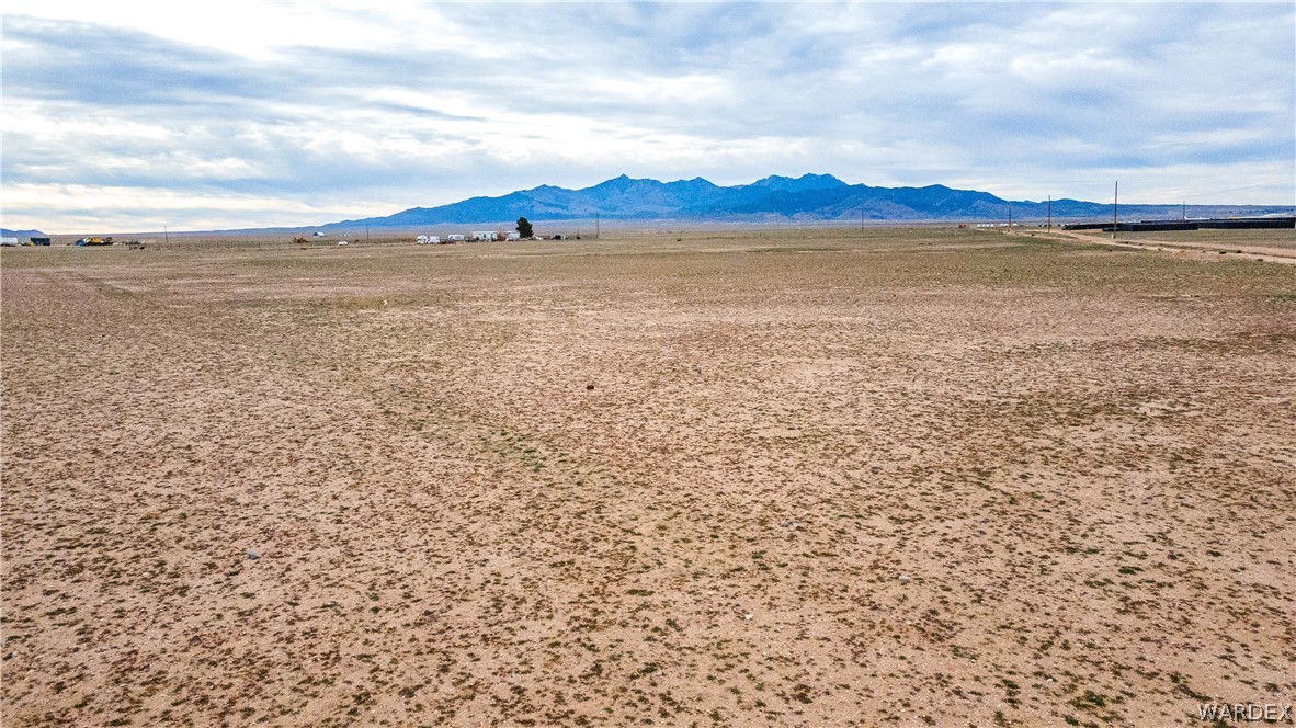0 East Parker Road, Unit 119 Kingman, AZ 86401 - Photo 16 of 16 Expansive open land featuring distant mountains, scattered low-lying vegetation, and a wide-open sky