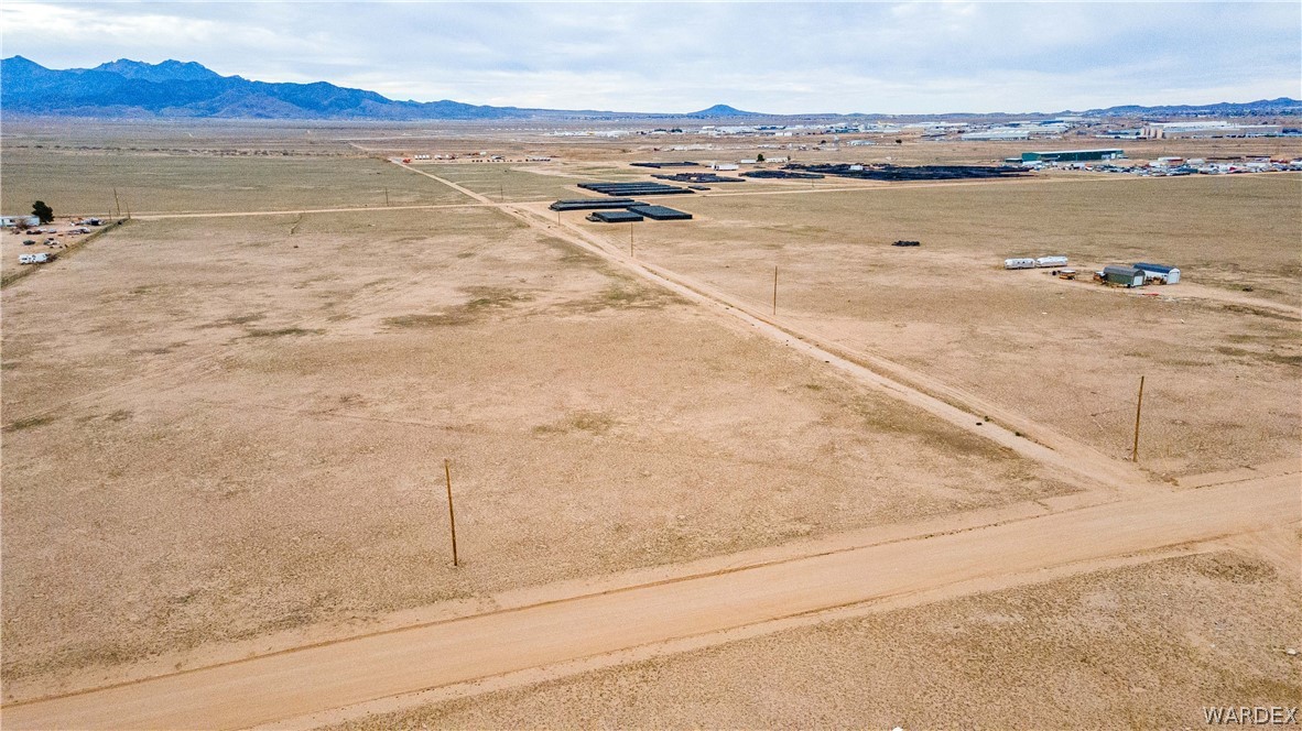 0 East Parker Road, Unit 119 Kingman, AZ 86401 - Photo 2 of 16 Expansive undeveloped land featuring a dirt road network and utility poles
