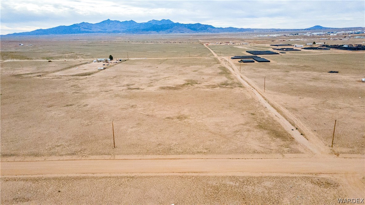 0 East Parker Road, Unit 119 Kingman, AZ 86401 - Photo 4 of 16 Expansive undeveloped land featuring a dirt access road and distant mountainous terrain