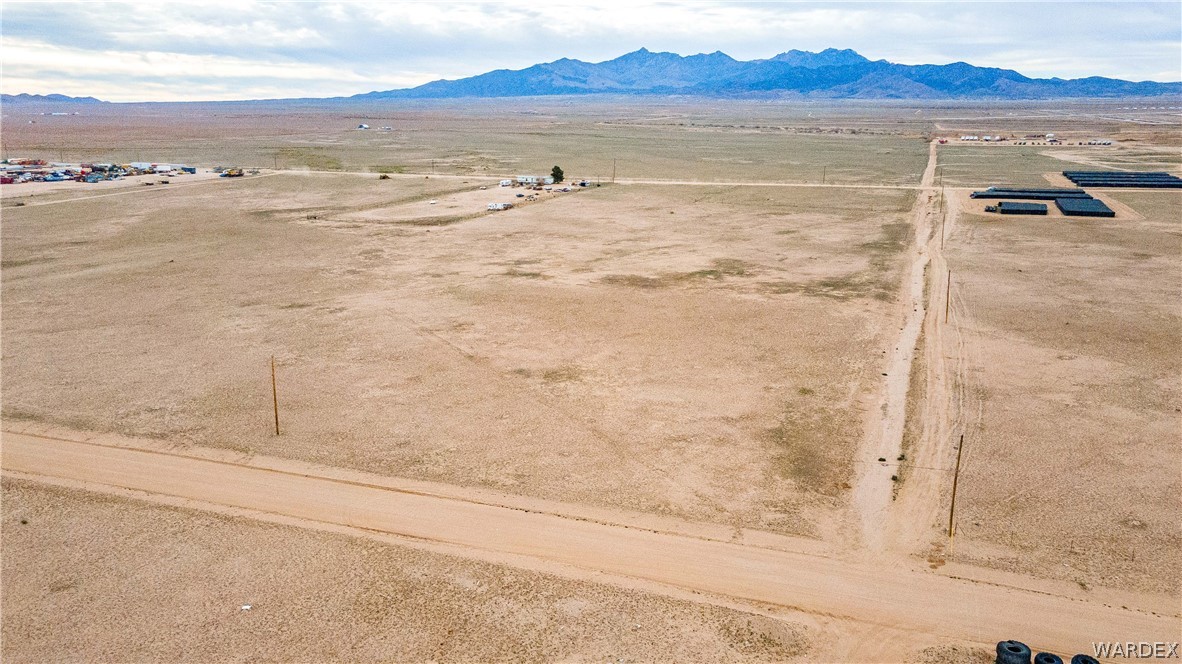 0 East Parker Road, Unit 119 Kingman, AZ 86401 - Photo 6 of 16 Expansive desert landscape featuring a dirt road and power poles