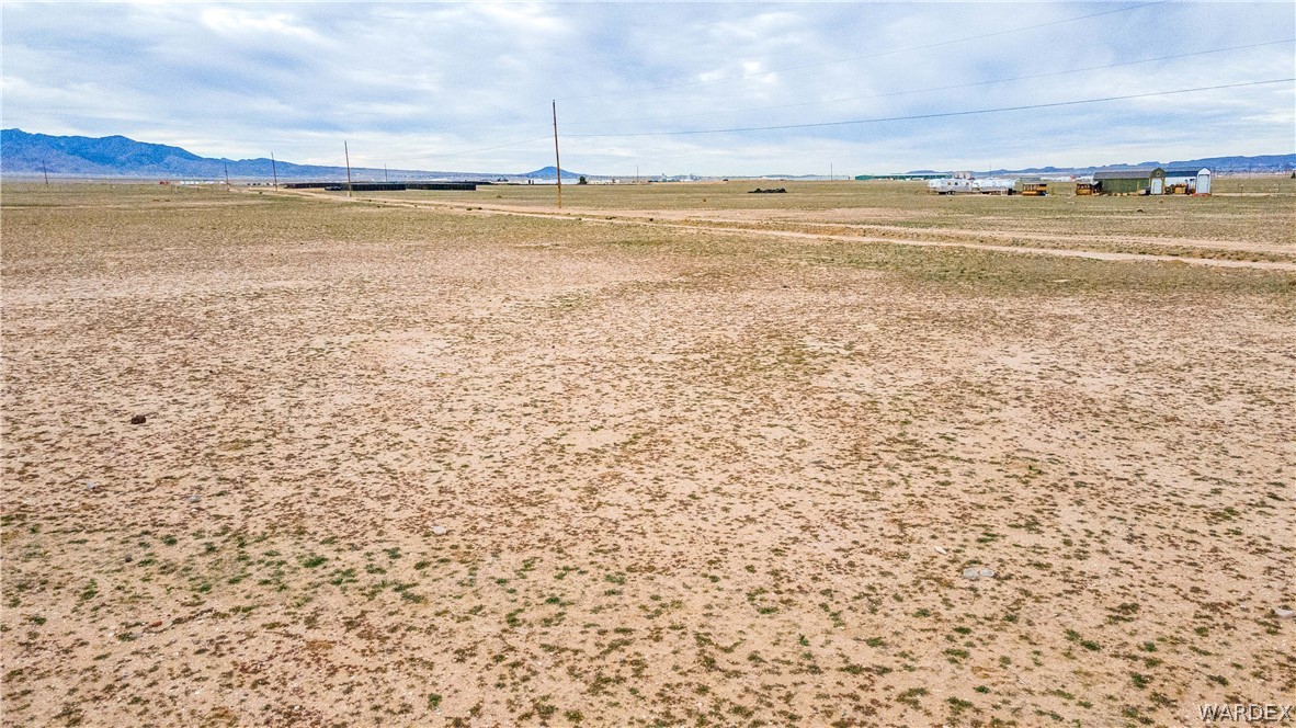 0 East Parker Road, Unit 119 Kingman, AZ 86401 - Photo 10 of 16 Expansive undeveloped land featuring natural desert vegetation, distant mountains, and visible utility poles