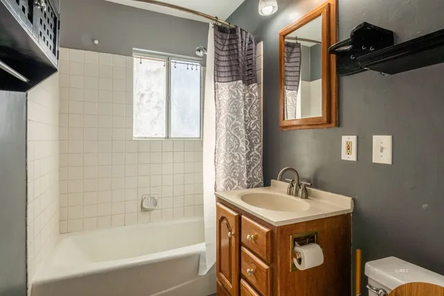 a bathroom with a sink mirror vanity and bathtub