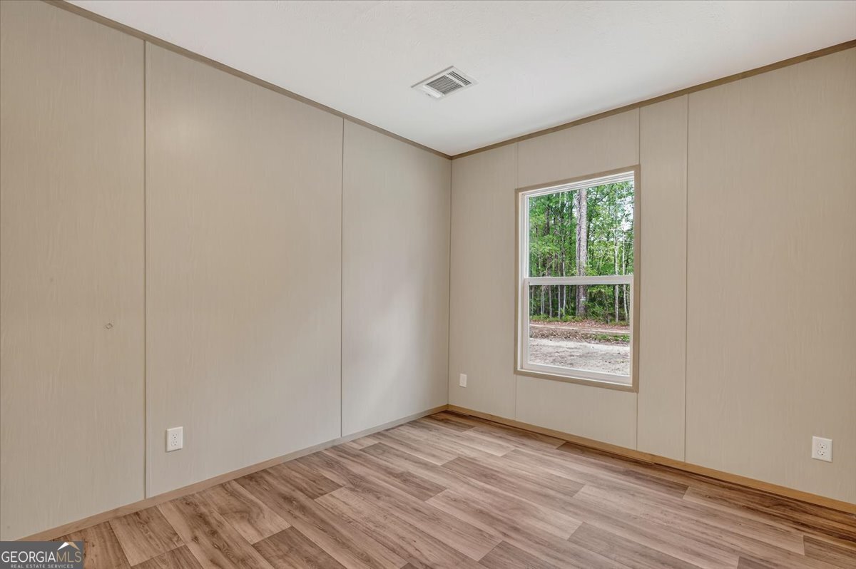 29 Clyde Road White Oak, GA 31568 - Photo 21 of 46 a view of an empty room with wooden floor and a window