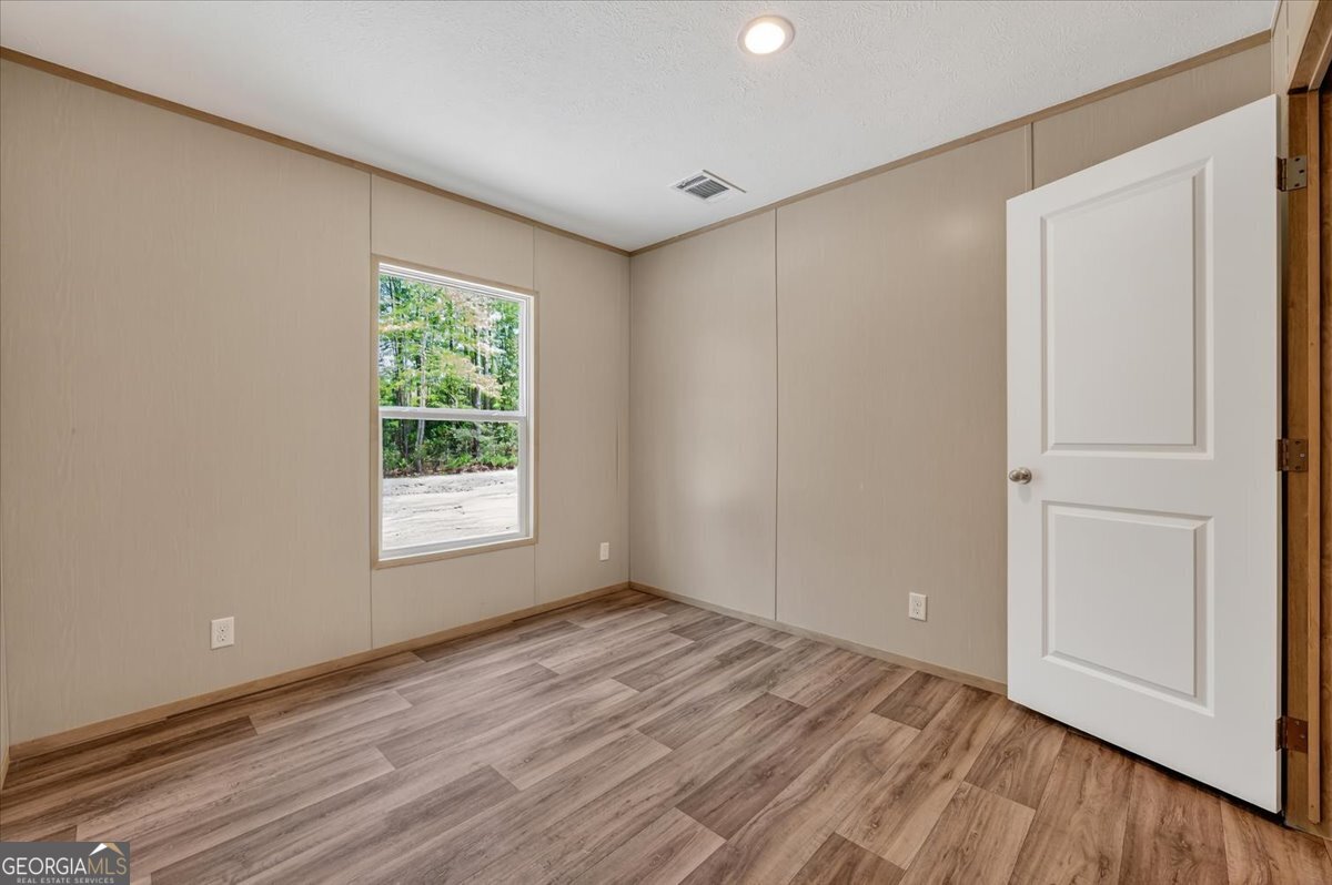 29 Clyde Road White Oak, GA 31568 - Photo 23 of 46 a view of an empty room with wooden floor and a window