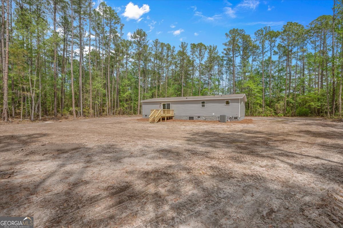 29 Clyde Road White Oak, GA 31568 - Photo 42 of 46 a view of a dry yard with trees in the background