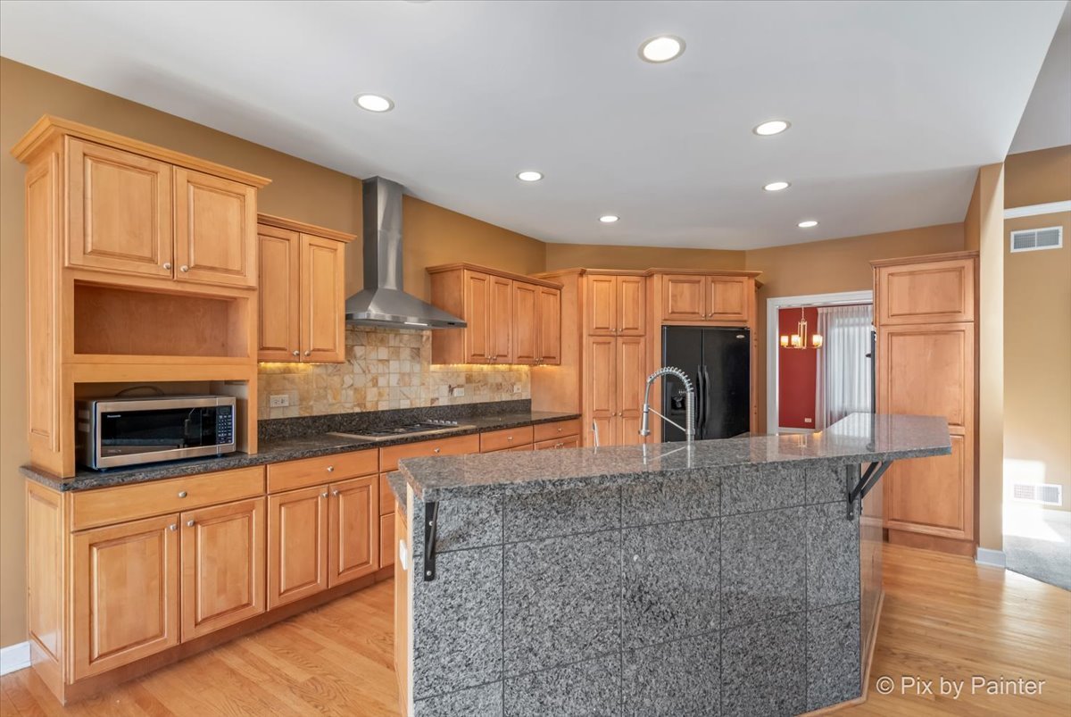 28935 Fox Street Cary, IL 60013 - Photo 11 of 50 a kitchen with stainless steel appliances granite countertop a stove a sink and a microwave