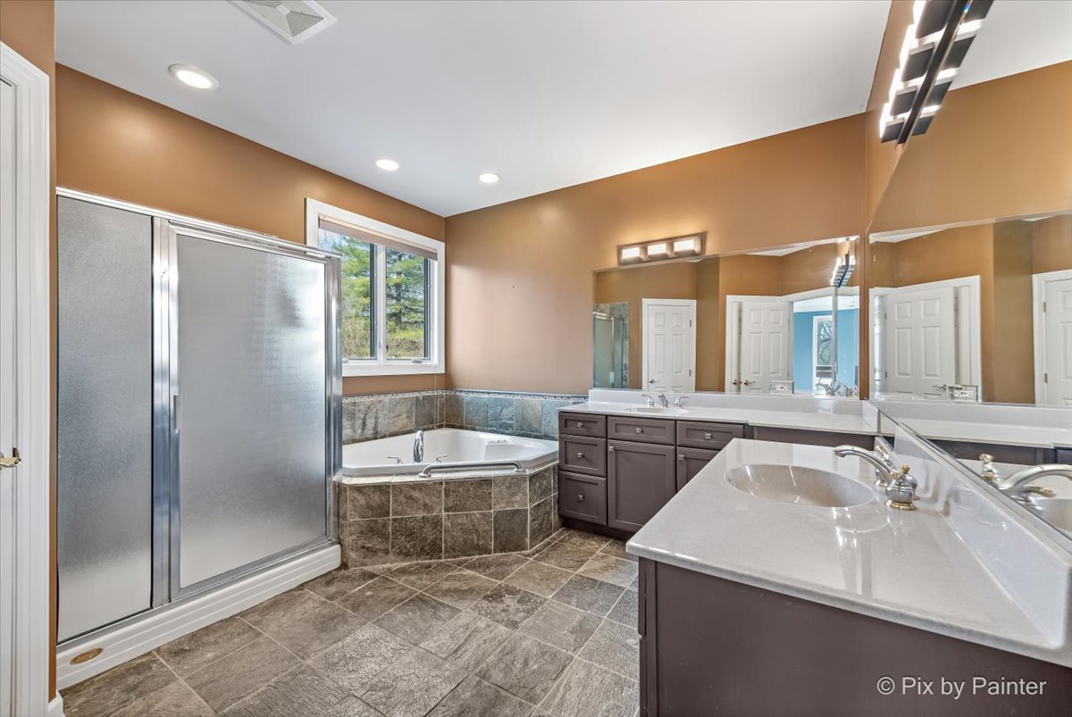 28935 Fox Street Cary, IL 60013 - Photo 22 of 50 a bathroom with a double vanity sink a large mirror and a bathtub