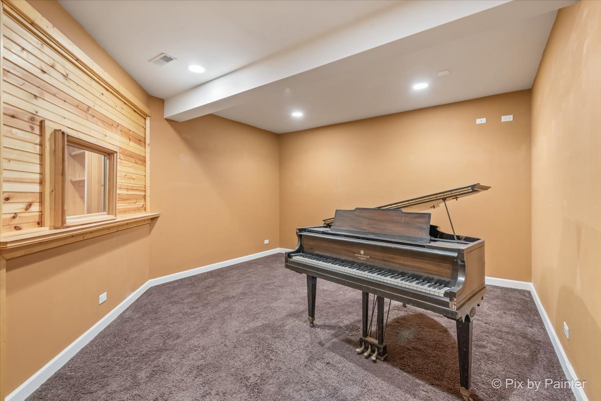 28935 Fox Street Cary, IL 60013 - Photo 37 of 50 a view of an empty room with a piano and wooden floor