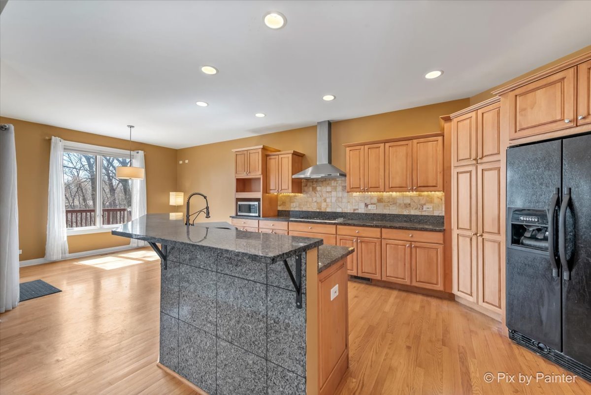 28935 Fox Street Cary, IL 60013 - Photo 8 of 50 a kitchen with stainless steel appliances granite countertop a refrigerator a sink a stove and white cabinets with wooden floor