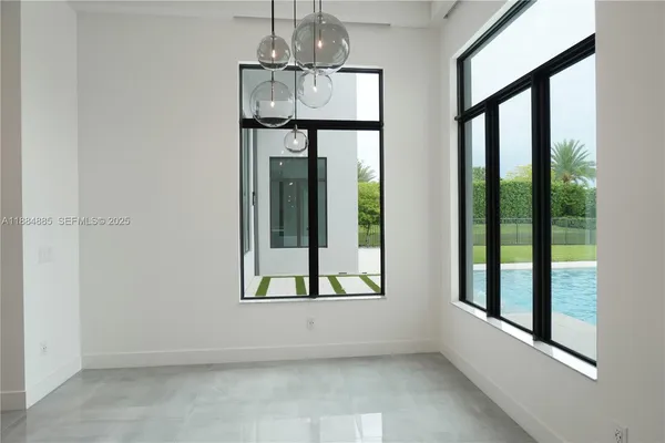 a view of an empty room with glass door and windows