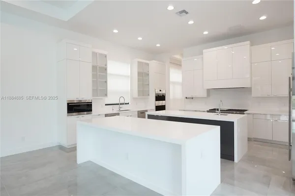 a kitchen with stainless steel appliances granite countertop a refrigerator and a stove