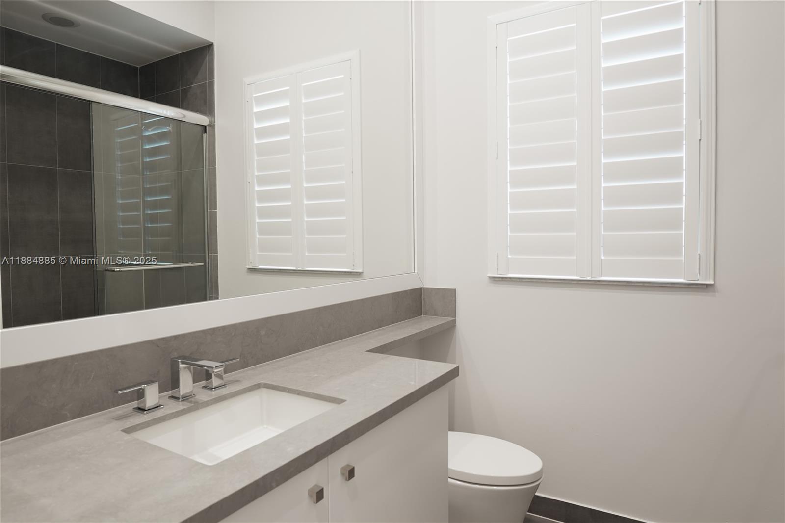 17241 Carretto Court Boca Raton, FL 33496 - Photo 6 of 35 a bathroom with a granite countertop sink toilet a mirror and a window