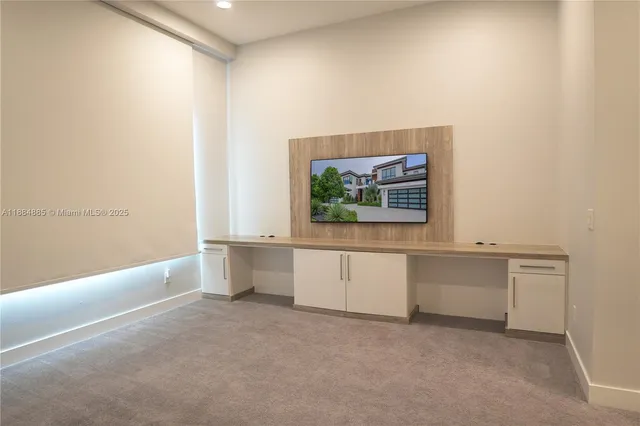 a view of an empty room with window and cabinet