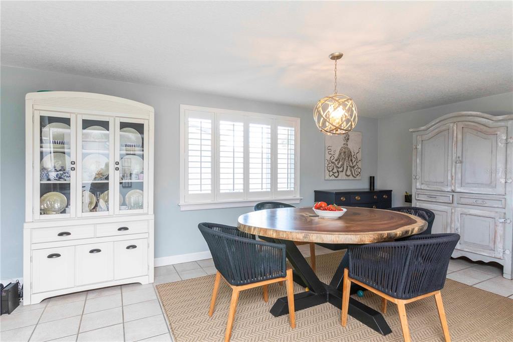 6324 Patella Avenue New Port Richey, FL 34653 - Photo 19 of 36 a dining room with furniture a chandelier and wooden floor