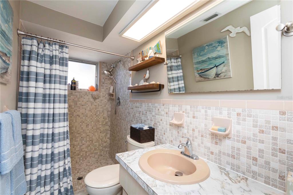 6324 Patella Avenue New Port Richey, FL 34653 - Photo 27 of 36 a bathroom with a toilet sink and mirror